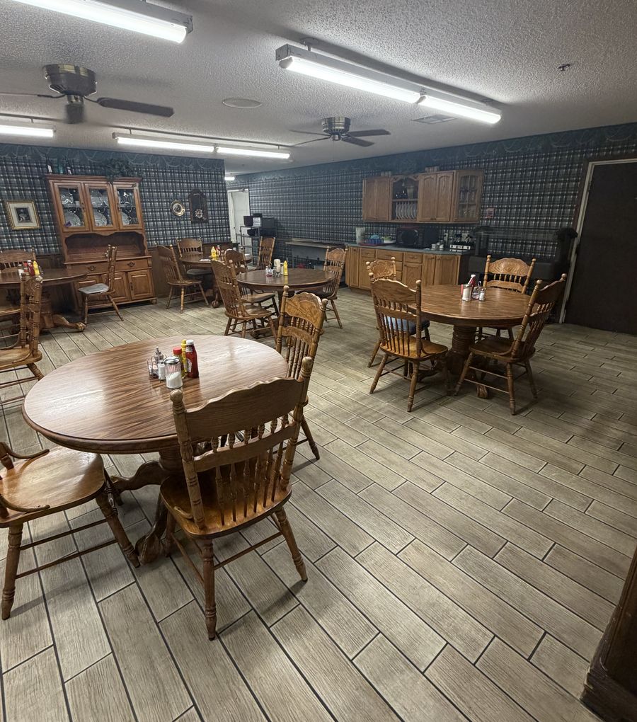 A dining room with round oak tables and a china hutch