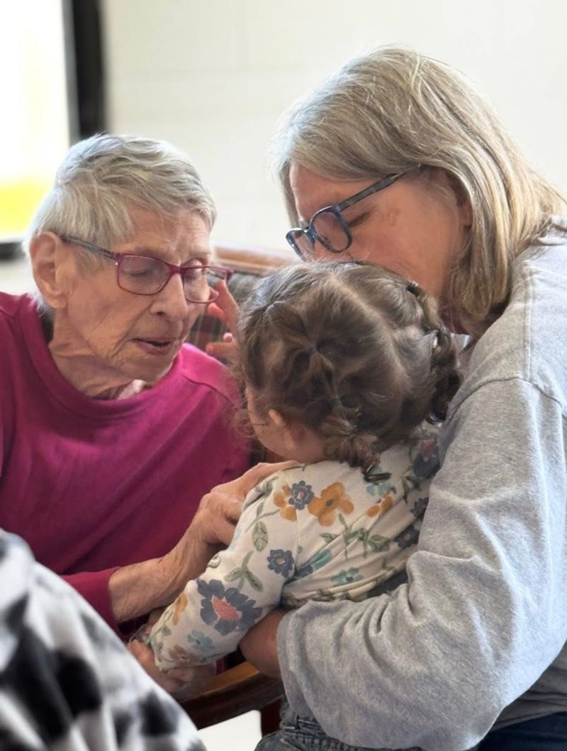 A resident sharing a tender moment with family and a toddler