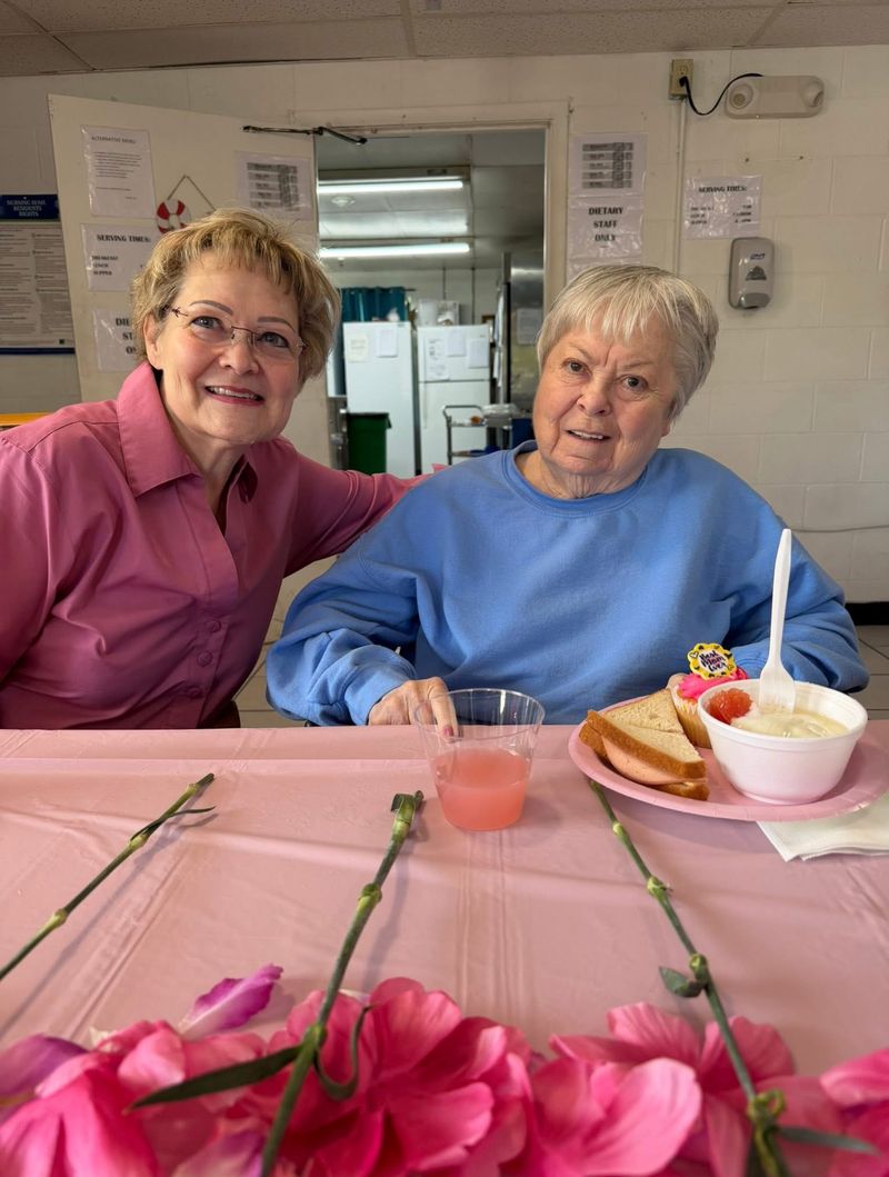 Two smiling women at a festive pink party table